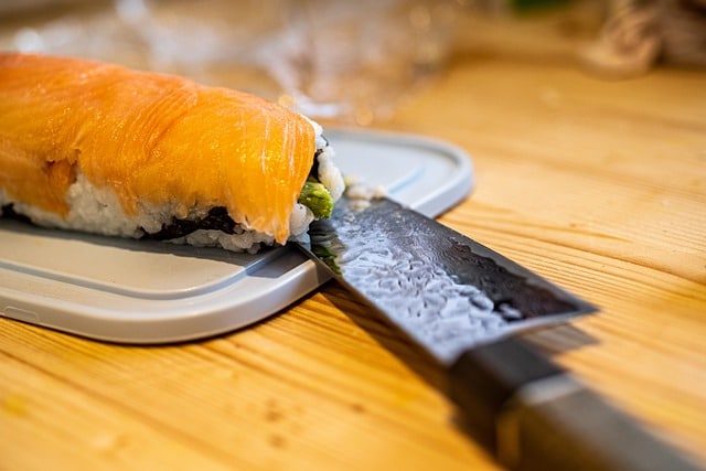 Ein japanisches Damastmesser liegt neben Sushi